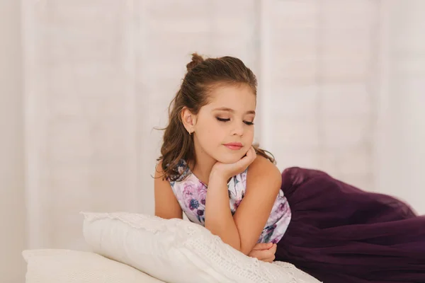 Niño feliz hembra en vestido púrpura. Hermoso maquillaje y peinado —  Fotos de Stock