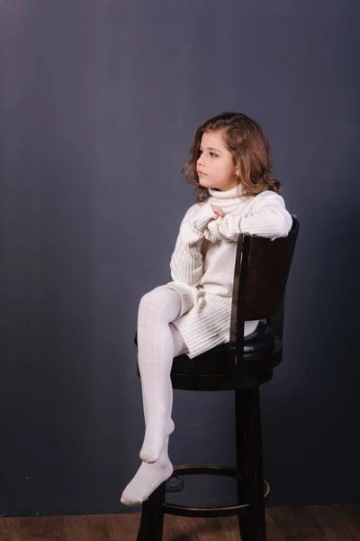 Niña hermosa con el pelo castaño en un suéter blanco. Estudio. Una princesa posa para un fotógrafo. Maquillaje y peinado — Foto de Stock