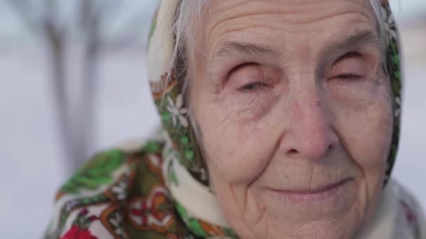 Closeup of elderly woman. Senion female in winter time. Old grandmother walking in the park — Stock Video