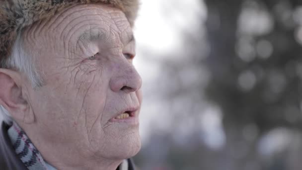 Close-up van oudere man in winter hoed. Oude man hebben misthins op gezicht. Gelukkig grootvader — Stockvideo