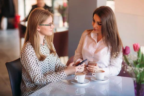 Mädchen nutzen ihre Arbeitspause, um Kaffee zu trinken und zu plaudern. Caffe Cappuccino. — Stockfoto