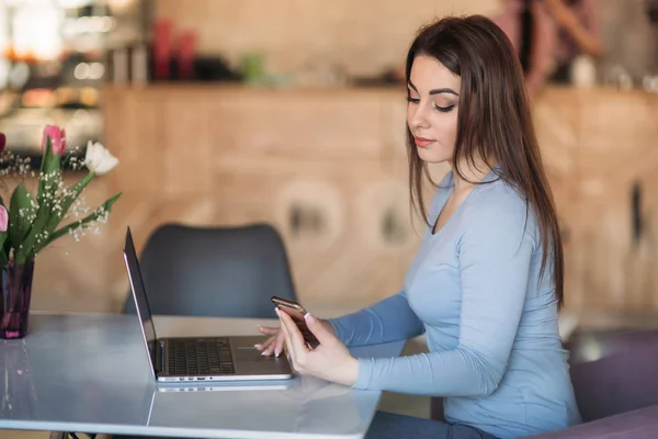 Красивая брюнетка бизнес женщина использовать телефон в кафе с ноутбуком — стоковое фото