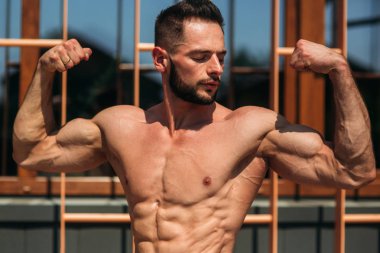 Genç bir atlet spor salonunda eğitiyor. Pazı gösterir