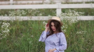 Genç hamile kadın alanında oturuyordu ve rahatla. O bir meyve sepeti aldı. Yaz