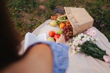 Meyve sepeti ekose alanında kürsüde. Kadın almak bir elma
