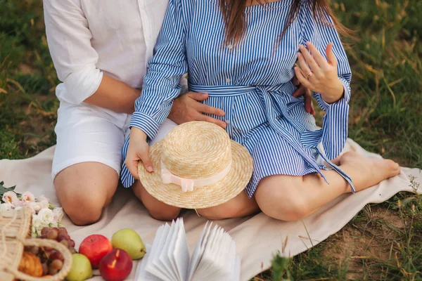 Nahaufnahme eines Mannes mit schwangerer Frau auf dem Feld. Gras — Stockfoto