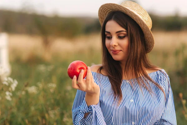 Красивая беременная женщина показывает и ест красное яблоко. Здоровое питание. Свежие фрукты. Счастливая женщина улыбается — стоковое фото