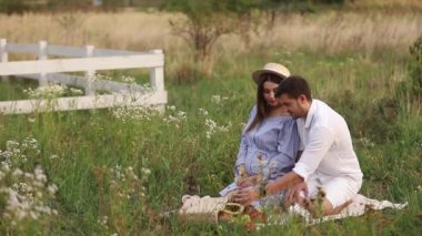 Gelecekte anne ve baba oturur alanında. Hamile kadın kocasıyla ellerini karnına koymak.