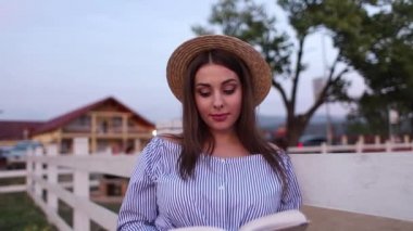 Güzel bir hamile kadın çiftlikte kitabını okudum. Tarafından fance stand ve kitaba bak. Sakin ol