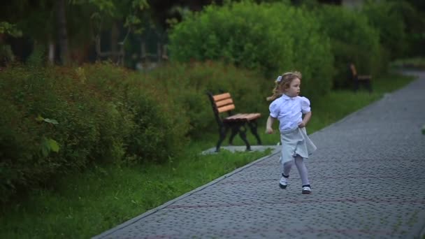 A menina corre e brinca. Eles rebentam com o dente-de-leão. pôr do sol — Vídeo de Stock