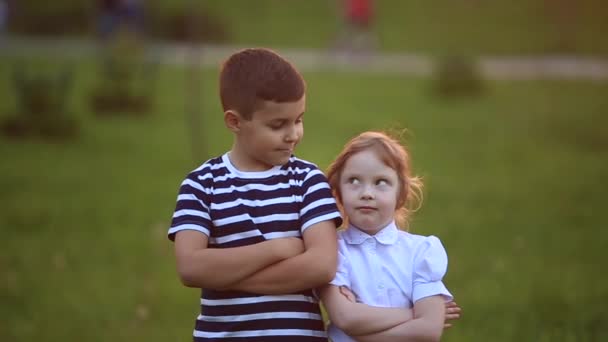 Little boy and girl run and play. They blow dandelion. sunset — Stock Video