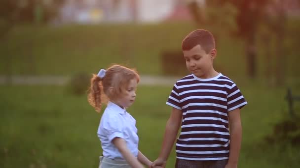 Μικρό αγόρι και κορίτσι τρέξει και να παίξει. Φυσούν πικραλίδα. ηλιοβασίλεμα — Αρχείο Βίντεο