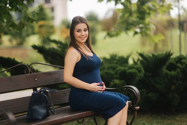 Terhes nő ül egy padon, közel a tó. Hat hónap a terhesség — Stock Fotó