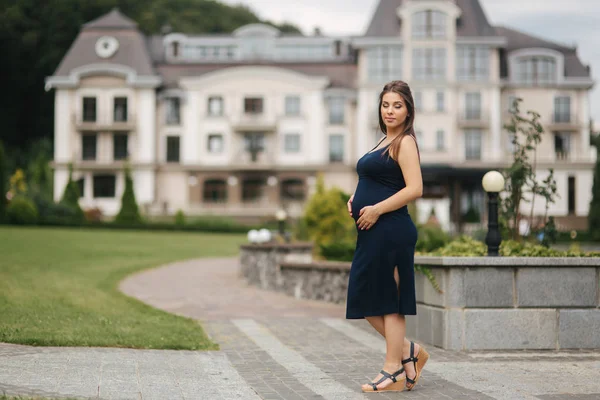 Schwangere im Kleid hält Hände auf Bauch — Stockfoto