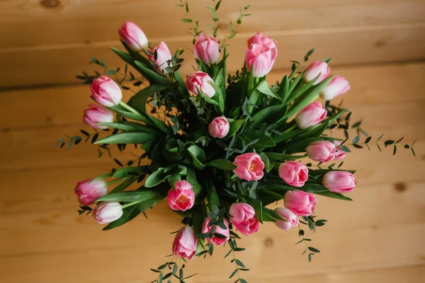 Un ramo de tulipanes rosados en un hermoso jarrón de cristal sobre fondo de madera. Primavera —  Fotos de Stock