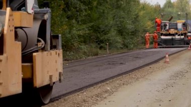 Sıkıştırma ve tesviye finişer taşıyıcı düz yeni yapılan bir yolda. Asfalt paver asfalt tamir şehir yolda uygulama