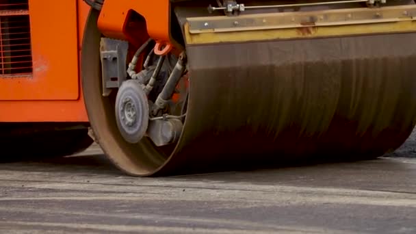 El pavimentador se mueve en una carretera plana de nueva construcción, embistiendo y nivelando.Pavimentadora de asfalto aplicando asfalto en la carretera de la ciudad reparada — Vídeo de stock