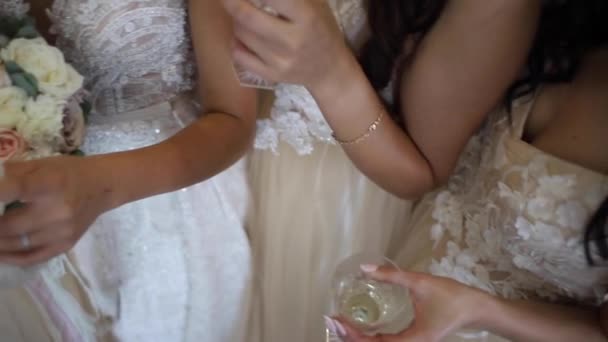 Koszorúslány esküvő. Lányok egy pohár champange tart. Háttérben virágok — Stock videók