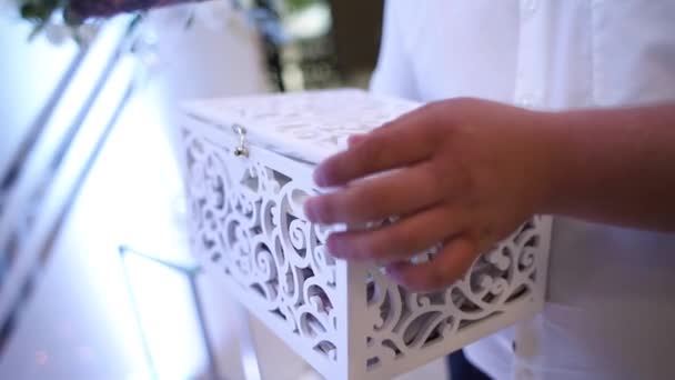 Белая коробка, в которую кладется конверт с деньгами — стоковое видео