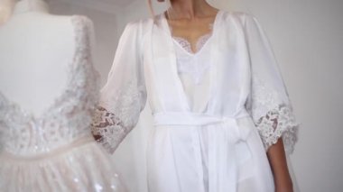 Seksi gelin düğün elbisesini tarafından ayakta. Güzel kız elbise bakmak. Eve gelin. Sabah