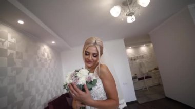 Zarif gelin tutuşsun düğün buketi. Güzel sarışın kız moda makyaj ve saç modeli ile. Bayan modeli Hotel