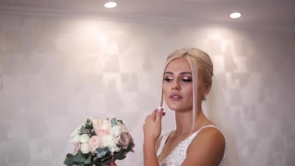 Eleganckie oblubienicy przytrzymaj Bukiet ślubny w ręce. Piękne blond włosy dziewczyna z mody makijaż i fryzurę. Kobieta w hotelu — Wideo stockowe