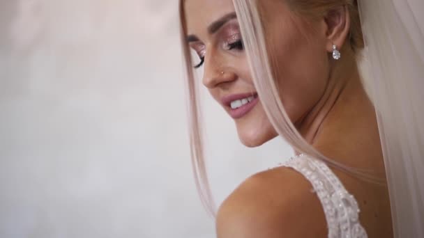 Primer plano de la novia hermosa con maquillaje de moda y peinado. Chica rubia del pelo — Vídeo de stock