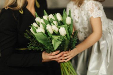 Küçük kızı anne buket çiçek ver. Anne ve kızı evde. Buket çiçek 8 Mart