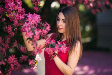 Güzel Bayan stand büyük çiçek açan ağaç voilet rengine göre. Mutlu kız makyaj bahar ile