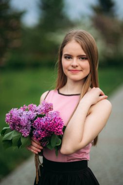 Sarı saçlı kız tutuşsun leylak bir buket. Dışarıda