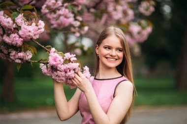 Sakura Japon çiçekli ağaç yakınındaki Avrupa erkek portresi. Sarı saçlı kız