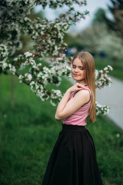 Prachtig blond haar meisje staande voor de bloeiende boom. mooie lente — Stockfoto