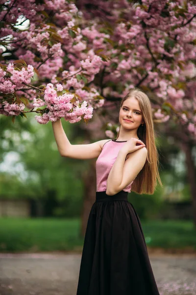 Portret Europy kobiet w pobliżu japoński kwitnienia drzewo Sakura. Blond włosy dziewczyna — Zdjęcie stockowe