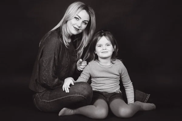 Foto em preto e branco de mãe e filha em estúdio. Balck fundo — Fotografia de Stock