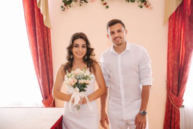 Damat ve gelin evlilik evin içinde ayakta. Beyaz güzel Çift