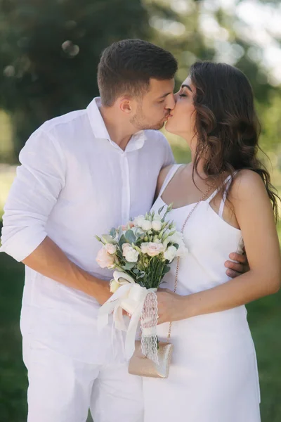 Novia y novio en el día de su boda caminando por el parque. Los recién casados pasan tiempo juntos. Acabo de casarme — Foto de Stock