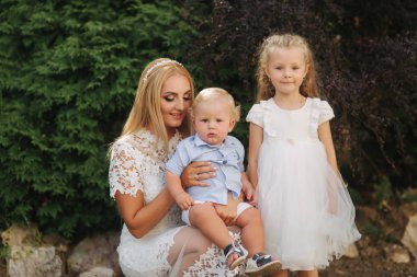 Güzel anne ile oğlu ve kızı walkink parkta. Sarı saçlı aile. Küçük çocuk