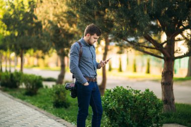 Model aramak için profesyonel fotoğrafçı leater kayışı ve en iyi fotoğraf makinesi kullanım telefon ile. Model için bekleyen fotoğrafçı