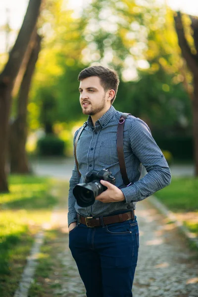 Retrato de fotógrafo guapo afuera. Correa de uso del hombre para camra profesional. Lente costosa — Foto de Stock