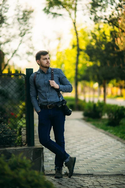 Photographe professionnel avec appareil photo debout à l'extérieur et attendre le modèle — Photo