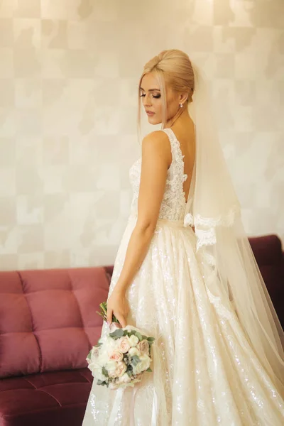 エレガントな花嫁ブーケ自宅の美しいウェディング ドレス。美しい化粧と髪型とブロンドの髪の女性 — ストック写真
