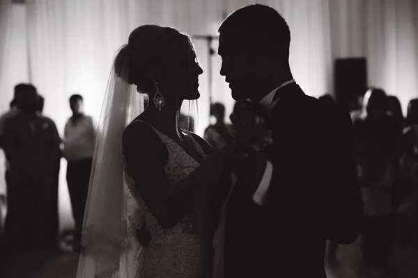 Primeira dança de recém-casados no restaurante. Silhueta de noivo e noiva. Preto e branco — Fotografia de Stock