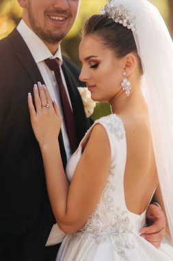 Güzel gelin kocası parkta. Sarı ağacın yanında yürüyorlar. Güzel makyaj