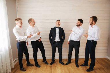 Yakışıklı damat ile evde onun sağdıç. Beş adam. Damat takım elbise, gromsmen beyaz gömlek giymiş. Komik çocuklar düğün