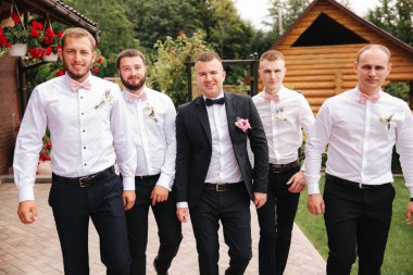 Şık sağdıç ile damat arka bahçesinde üzerinde duran ve düğün töreni için hazırlamak. Arkadaş zaman harcamak birlikte dışarıda