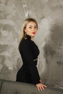 Studio siyah elbiseli çekici genç kadın. Sarı saçları zarif bayanla