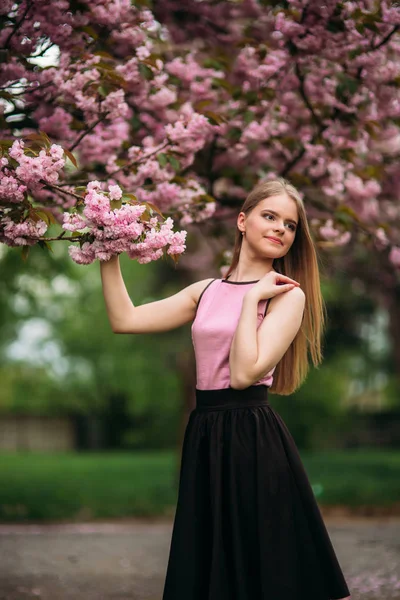 Porträtt av Europeiska kvinna nära japanska blommande trädet av sakura. Blont hår flicka utanför — Stockfoto