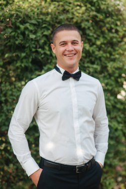 Parkta yürüyen genç adam. Whitr gömlekli yakışıklı damat