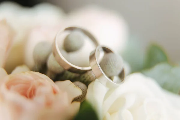 Prsteny z bílého zlata na svatební kytici. květiny — Stock fotografie