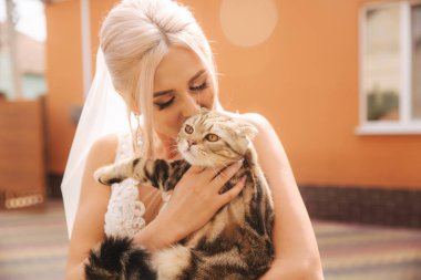 Güzel sarı saçlı gelin ile onu evde beslenen hayvan. Kedi gelinler ellerinde